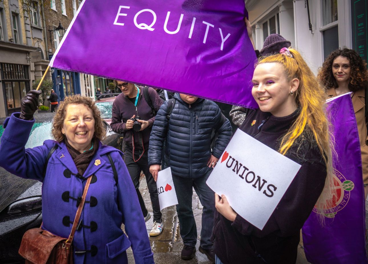 Su Gilroy and Amanda Grace pose with an Equity flag and an I Heart Unions sign during the Culture Tour across London.