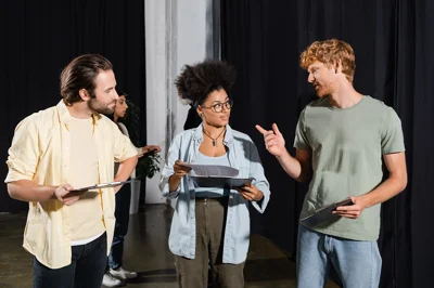 Three people with clip boards talking back stage