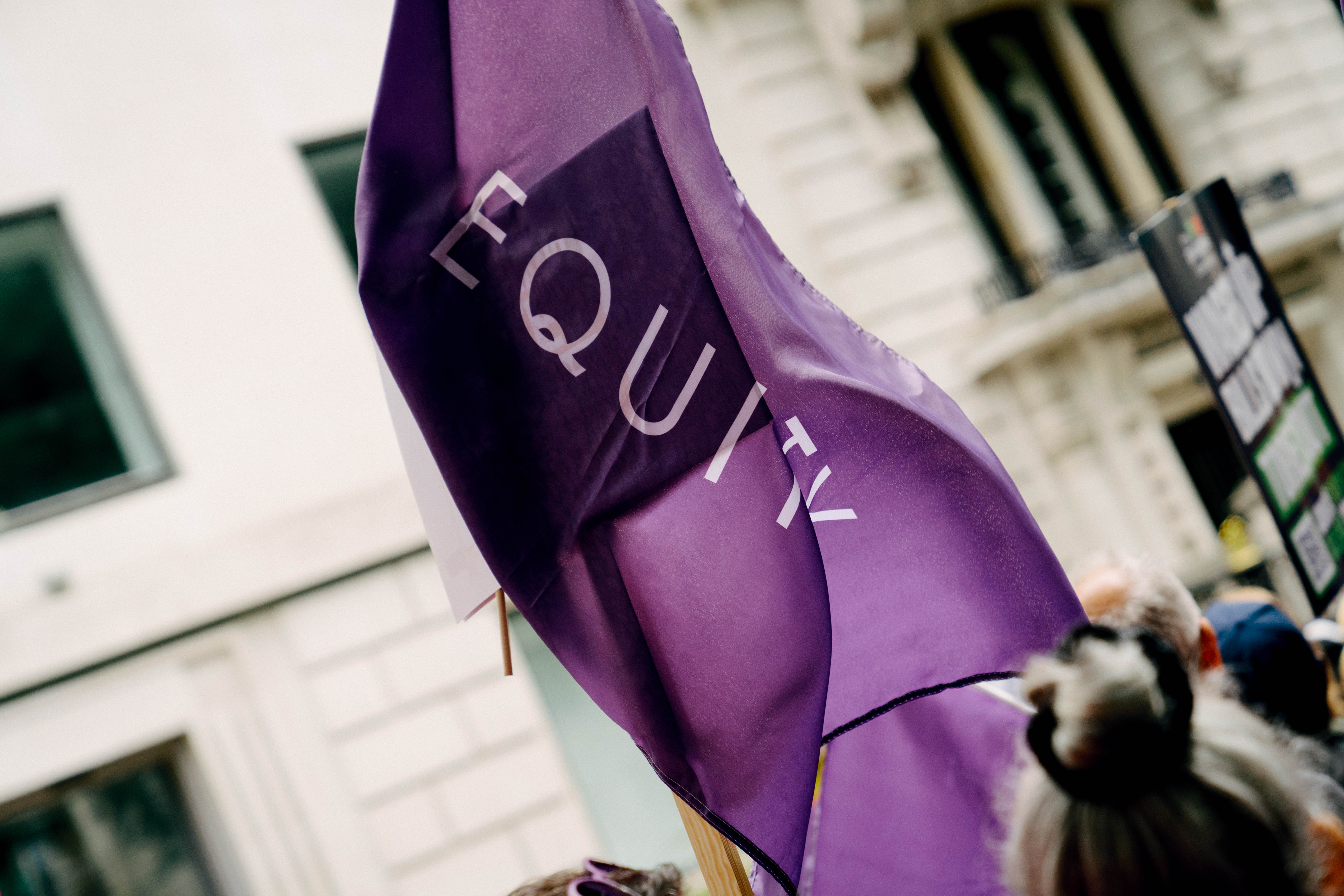 A billowing purple flag displaying a lilac Equity wordmark