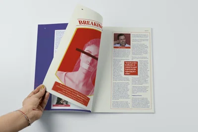 Hand turning pages of Equity magazine