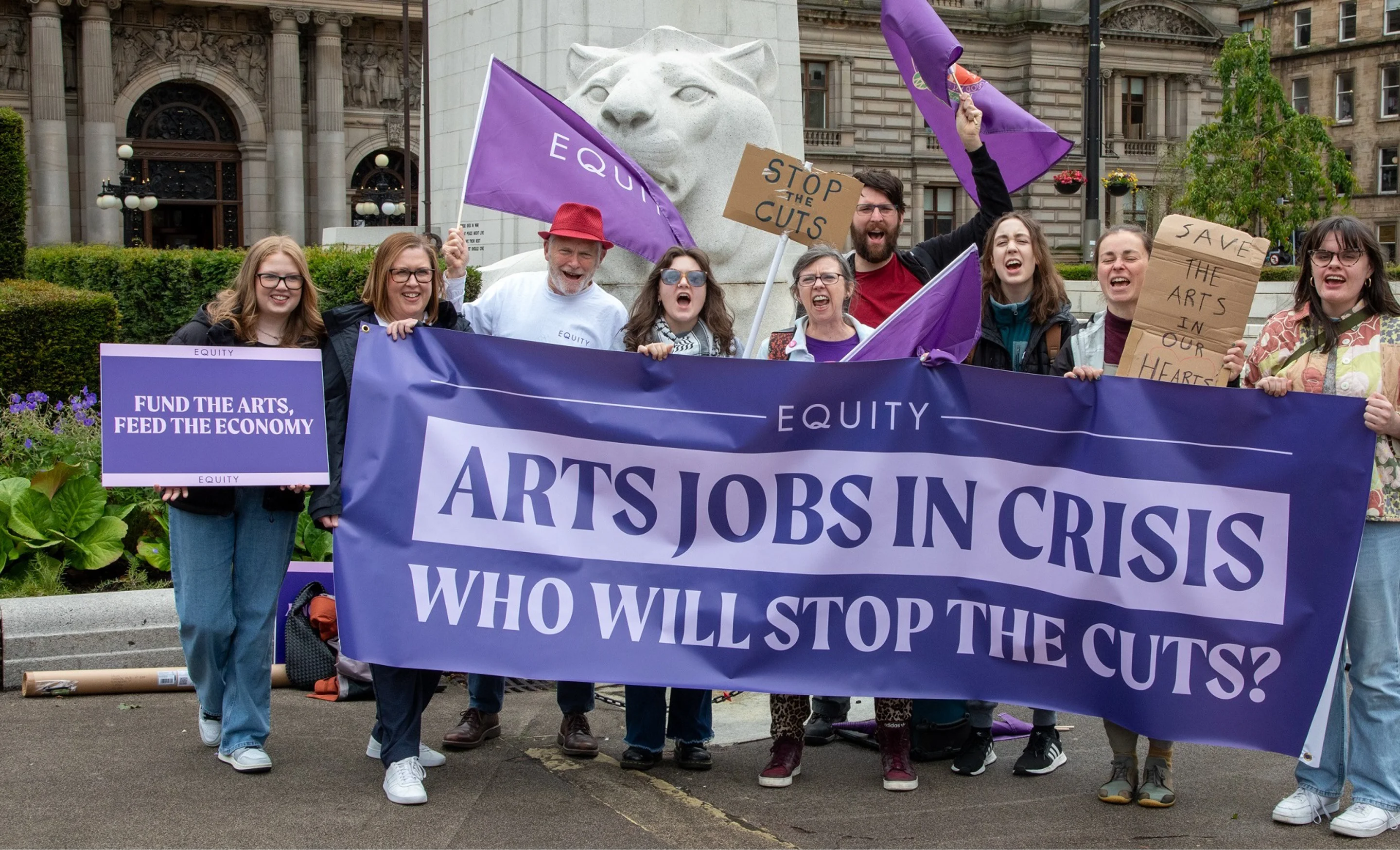 Group of protesters in Glasgow holding "Fund the arts" signs