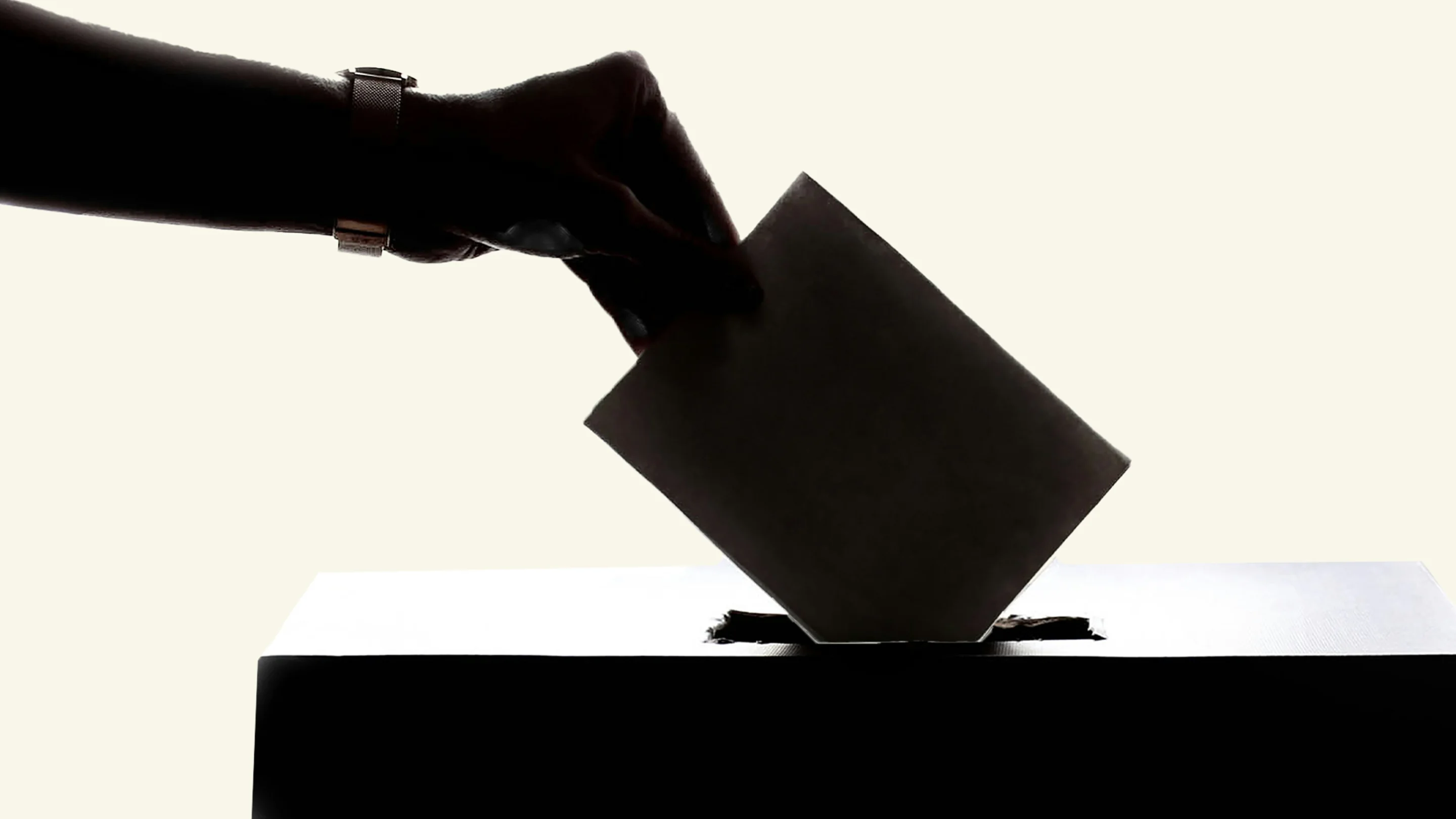 Hand putting a voting paper in a ballot box