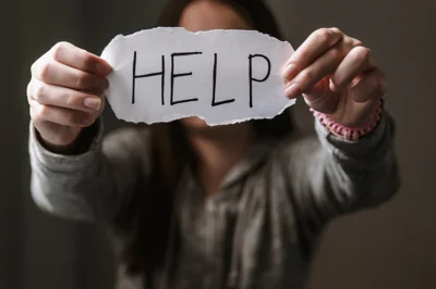 Decorative image: woman holding sign saying help