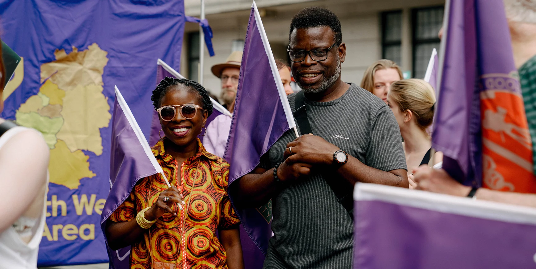 Equity Members At Demo smiling and holding flags