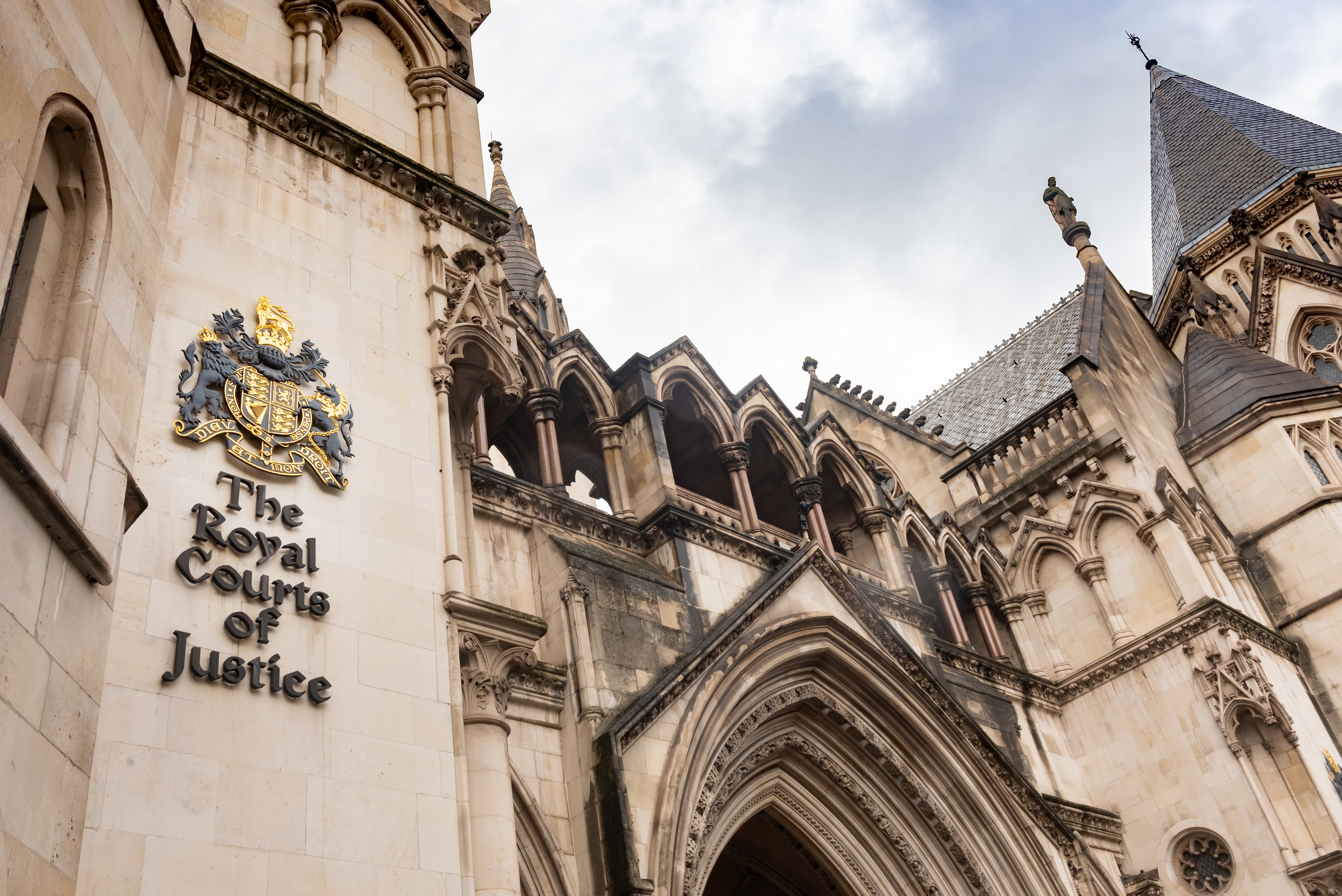 Photo shows close up of Royal Courts of Justice emblem on court building which is in gothic revival style