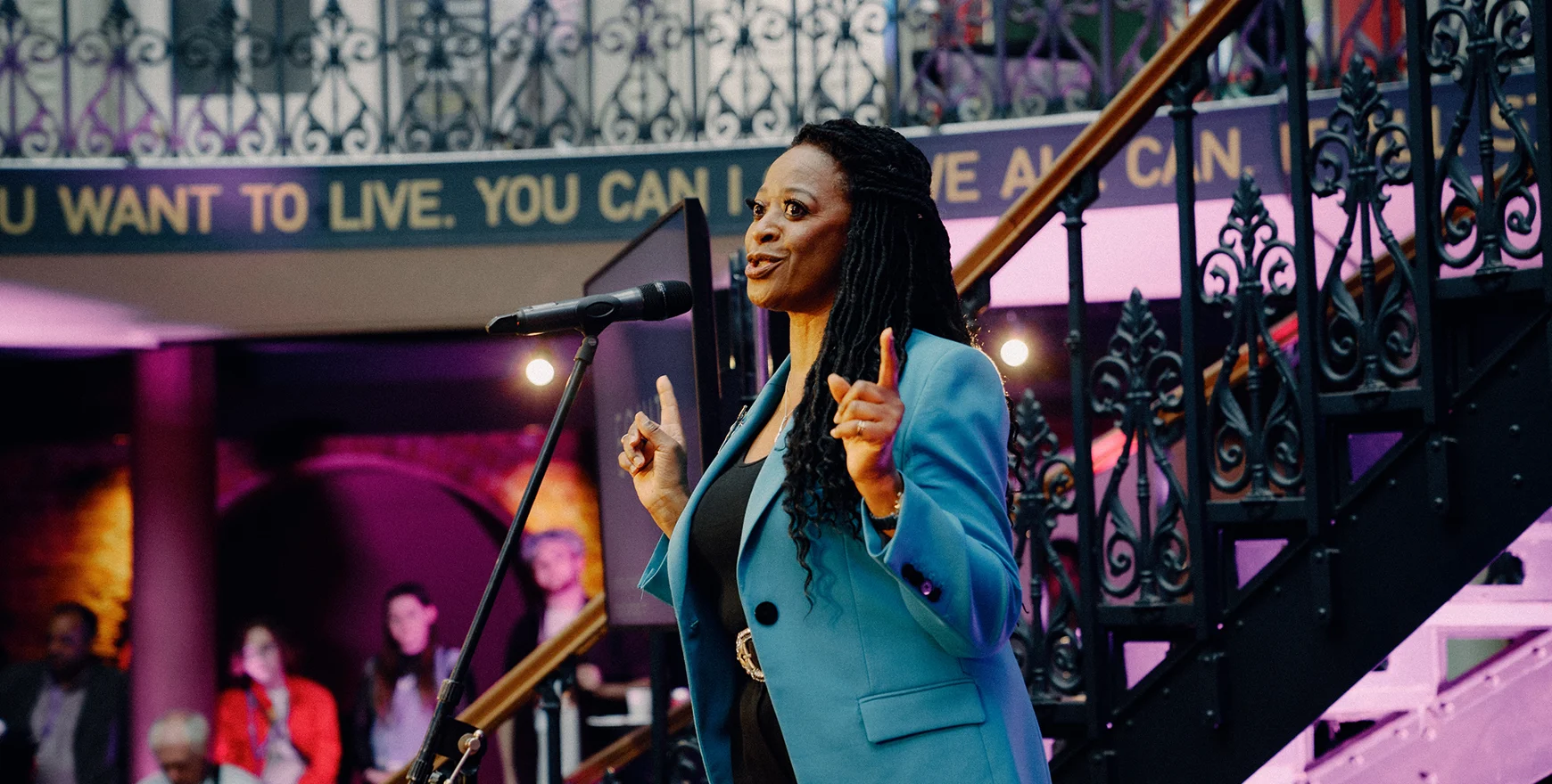 Woman speaking on stage at rally at Equity conference