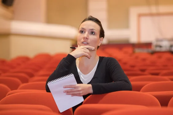 Woman sitting in theatre with script