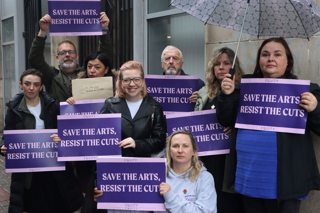 Photo shows Equity's Northern Ireland Committee holding 'Save The Arts Resist the Cuts' placards 