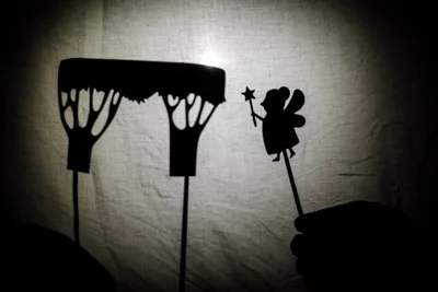 photo shows shadow puppet show with fairy with wand and woodland